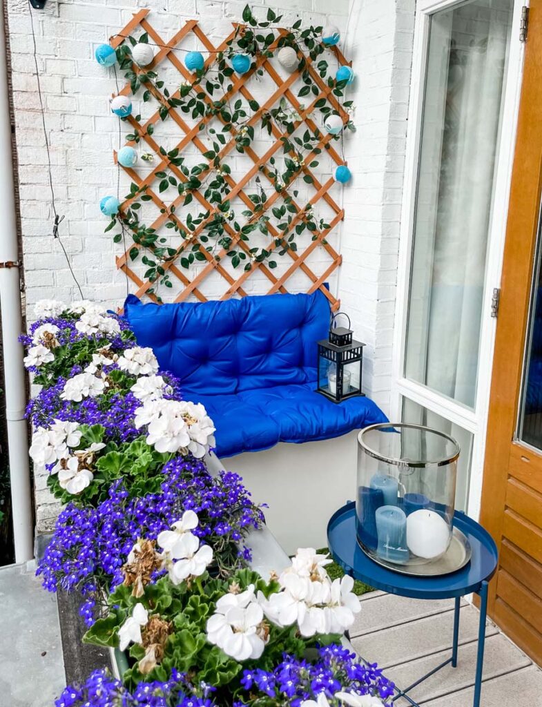 Balcony with blue sofa and hanging flowers