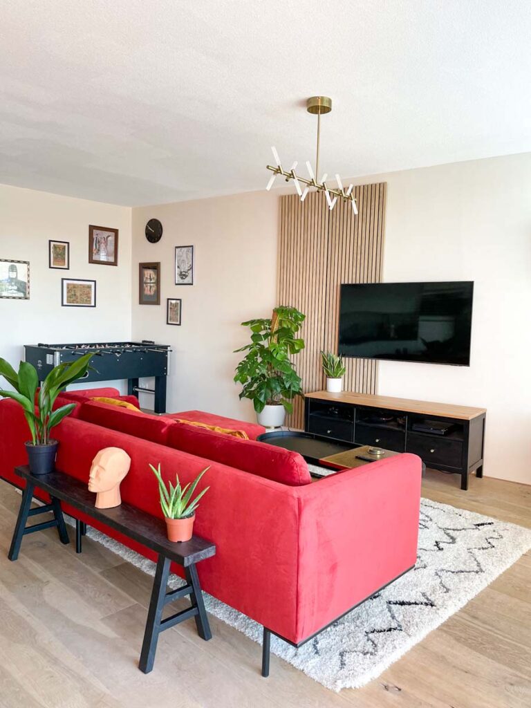 Red velvet couch in living room facing tv