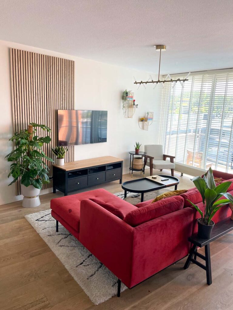 Living room with floating tv and red velvet sofa