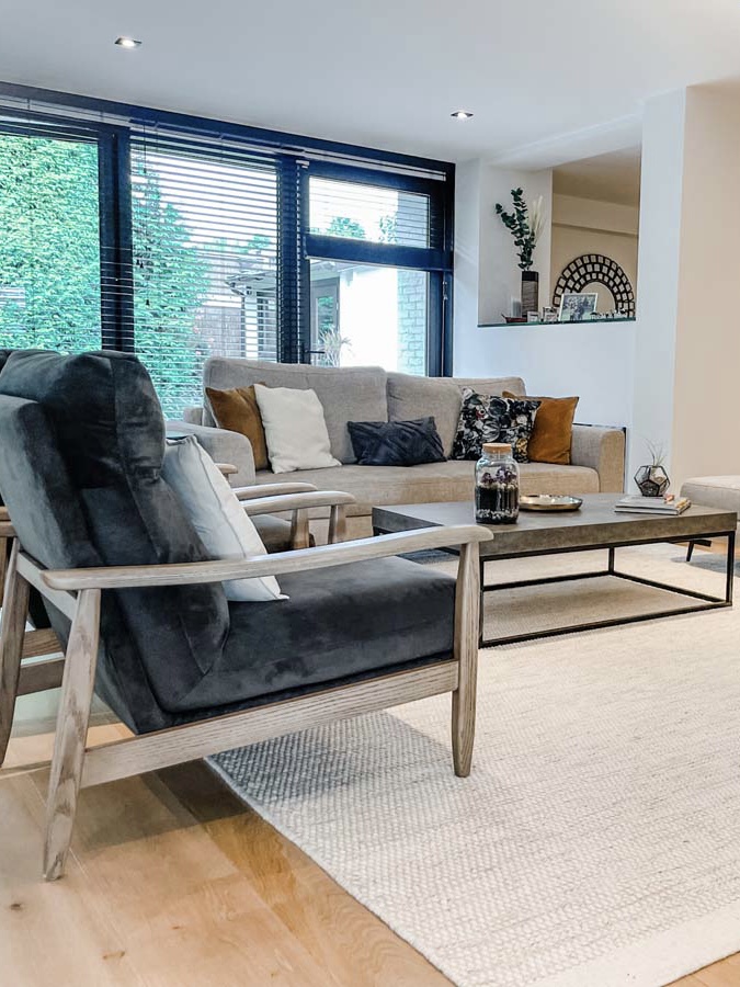 Neutral living room with three seater sofa and two arm chairs