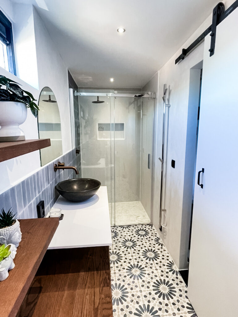 blue tile and walnut wood bathroom with floating vanity