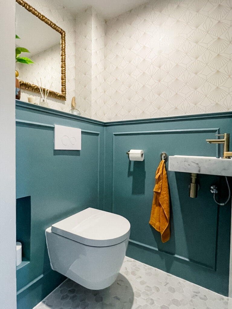 small toilet remodel in blue and gold with marble sink